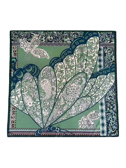 Green square scarf with bird, butterfly, floral, and geometric motifs laid flat