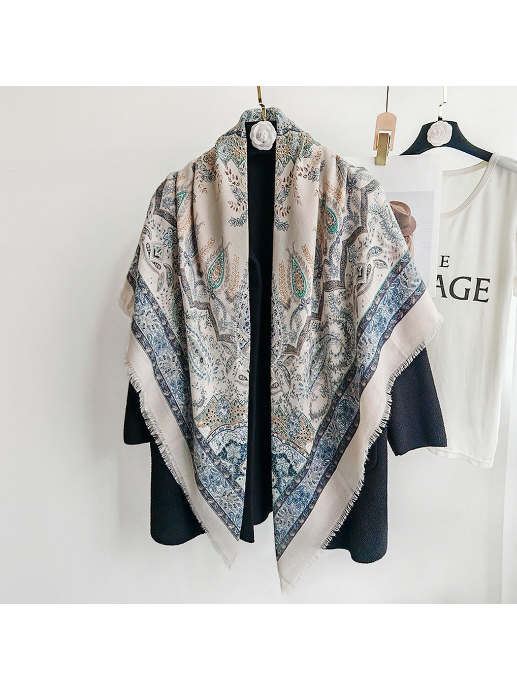 Light blue paisley scarf draped over a black coat