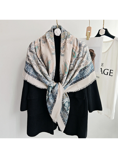 Light blue paisley scarf tied over a black coat