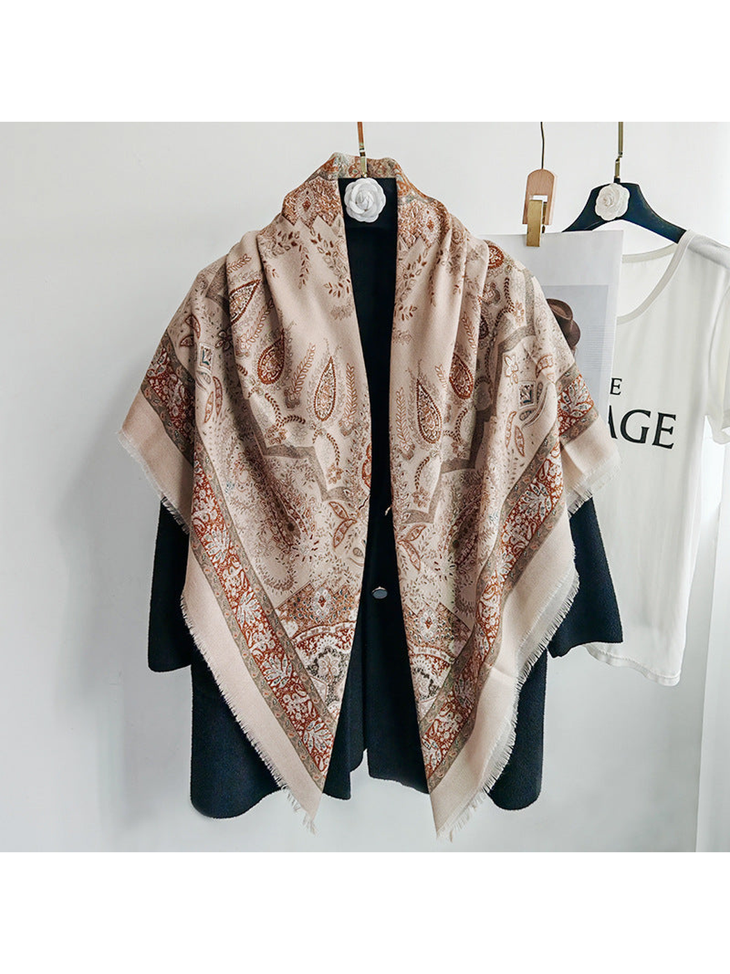 Khaki paisley scarf draped over a black coat