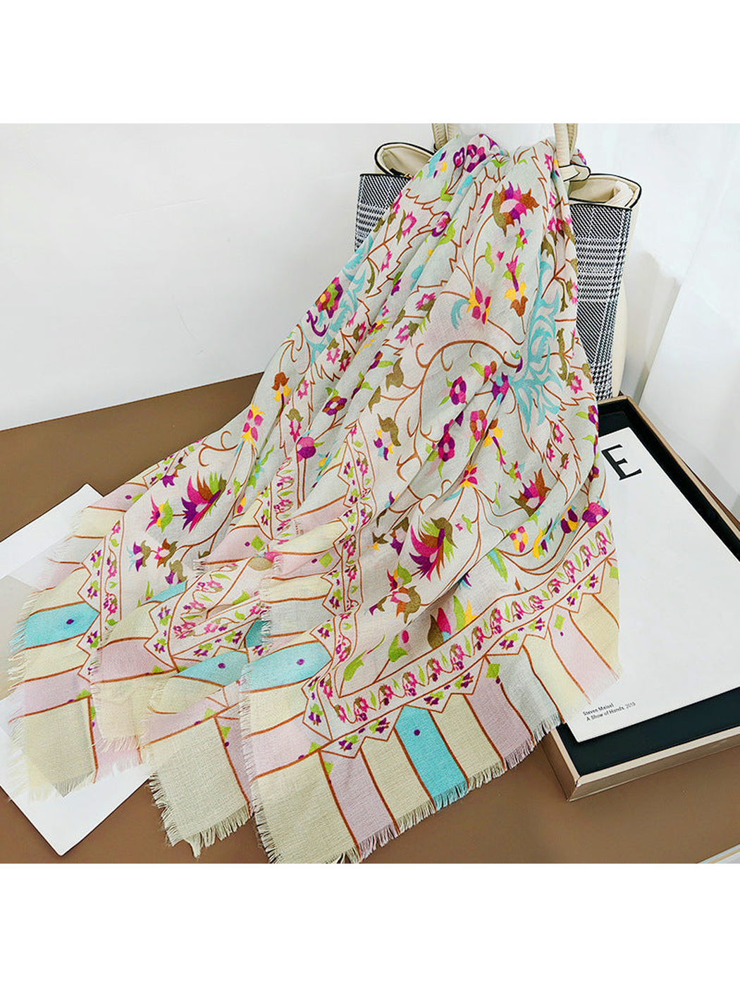 Multicolor floral scarf draped over a handbag and decorative prints