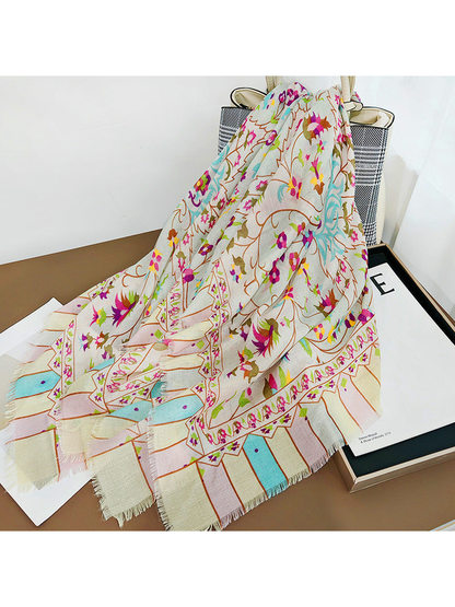 Multicolor floral scarf draped over a handbag and decorative prints