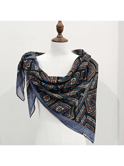Multicolor geometric square scarf tied over one shoulder on a mannequin