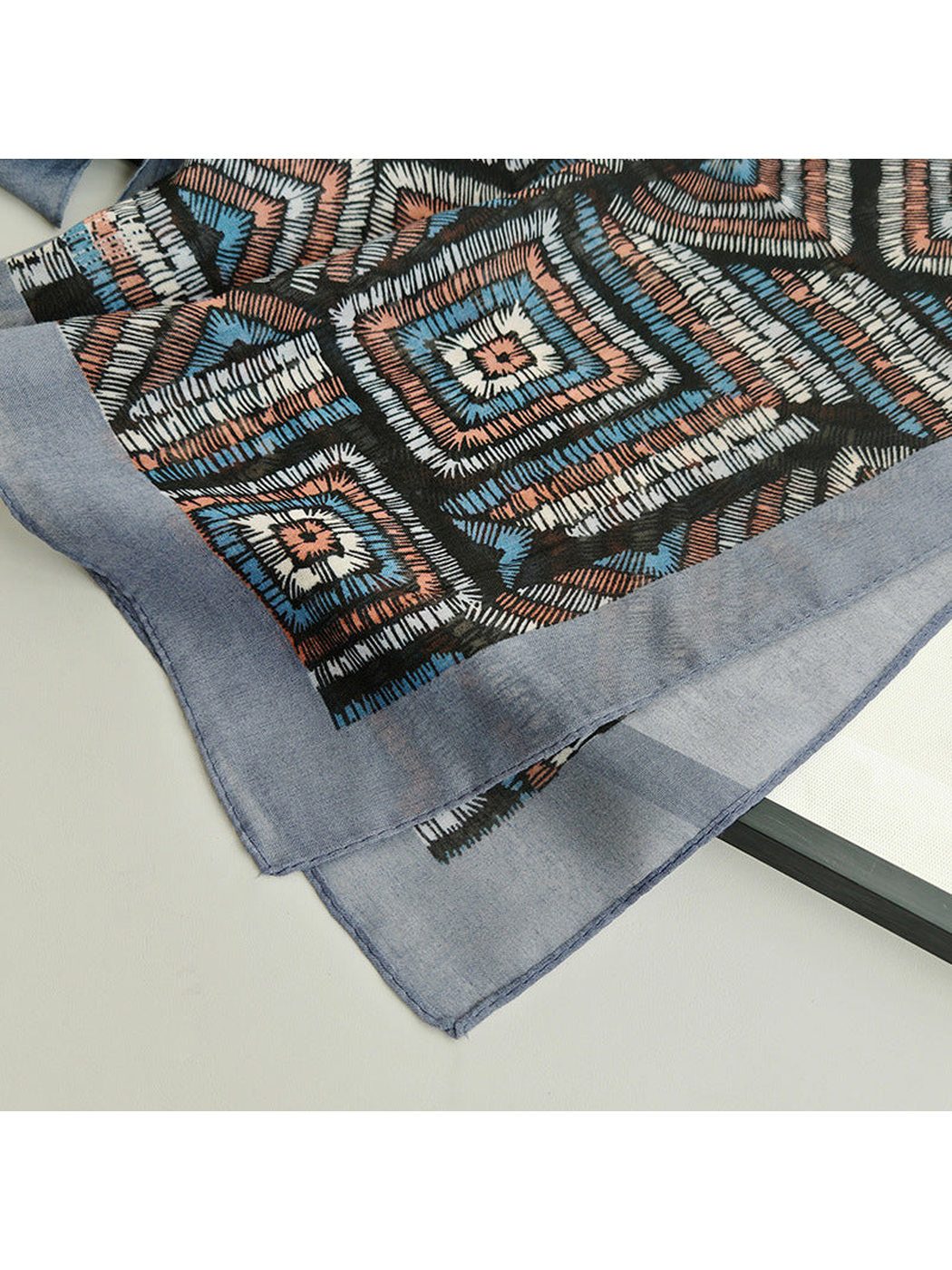Close-up of the geometric pattern and blue-gray scarf border