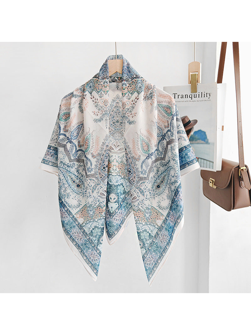 Blue paisley square scarf draped over a hanger