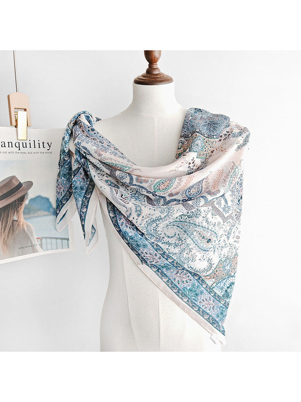 Blue paisley square scarf draped across a mannequin's shoulders
