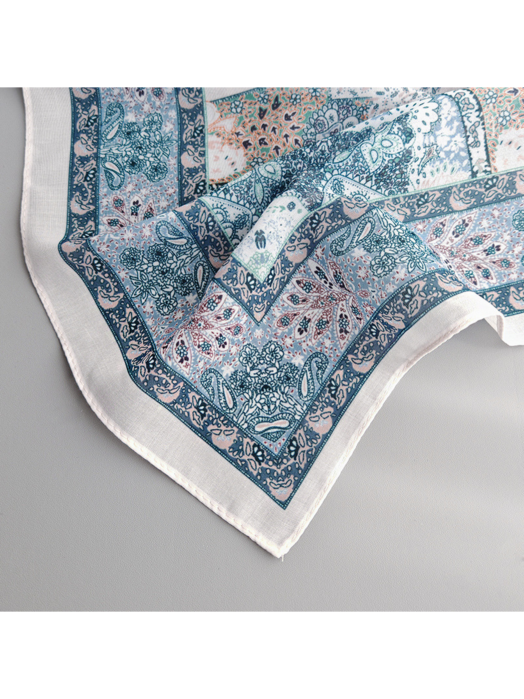 Close-up of the scarf's decorative border, ivory margin and stitched edge
