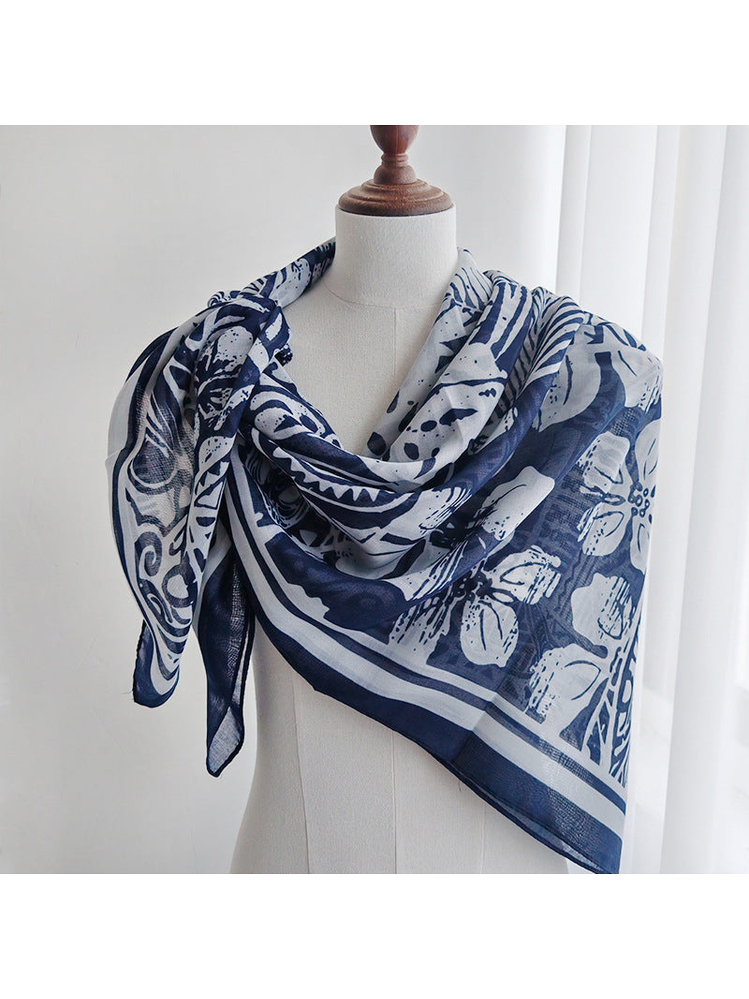 Navy and ivory patterned square scarf wrapped around a dress form