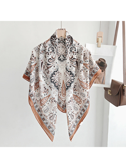 Ivory paisley square scarf draped over a hanger