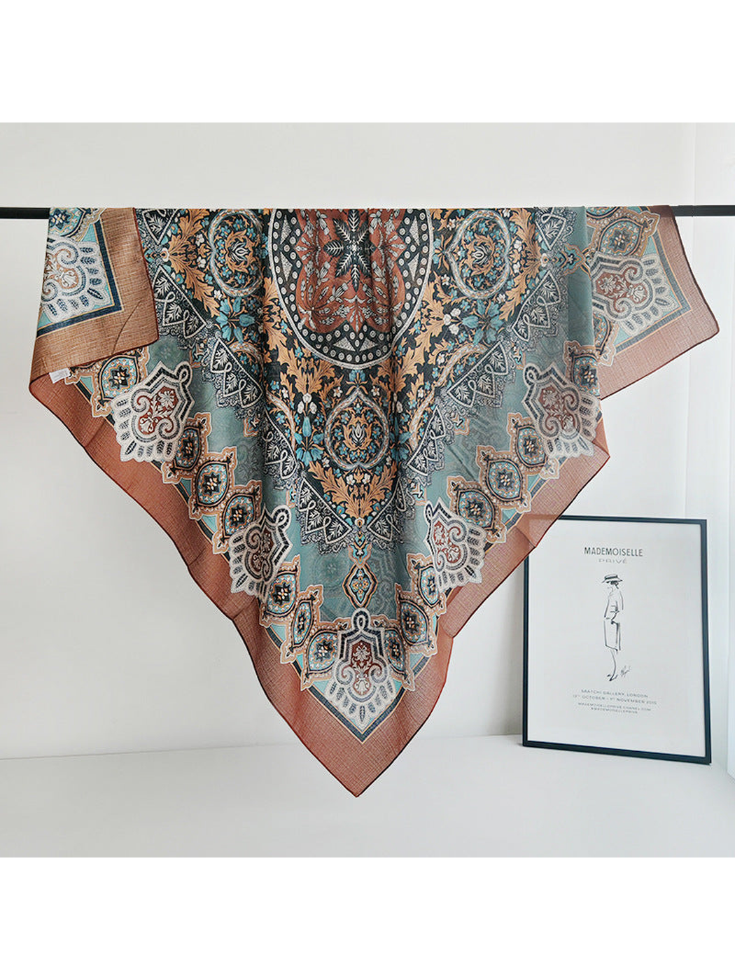 Ornamental square scarf draped over a rail to show the full pattern