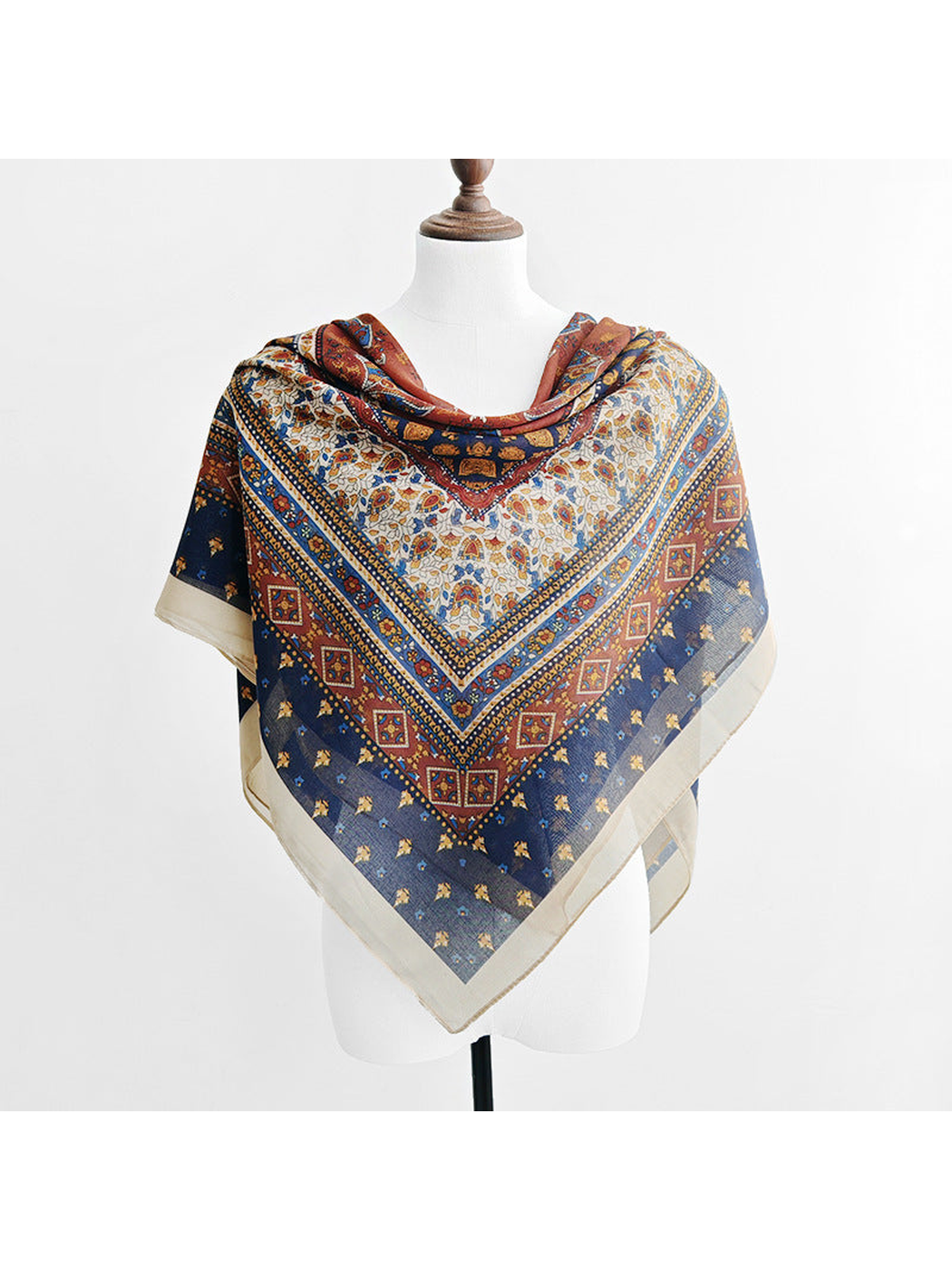 Multicolor ornamental scarf styled as a triangular front drape on a mannequin
