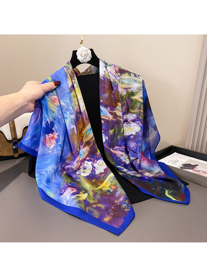 Multicolor square scarf with blue border draped over a hanger