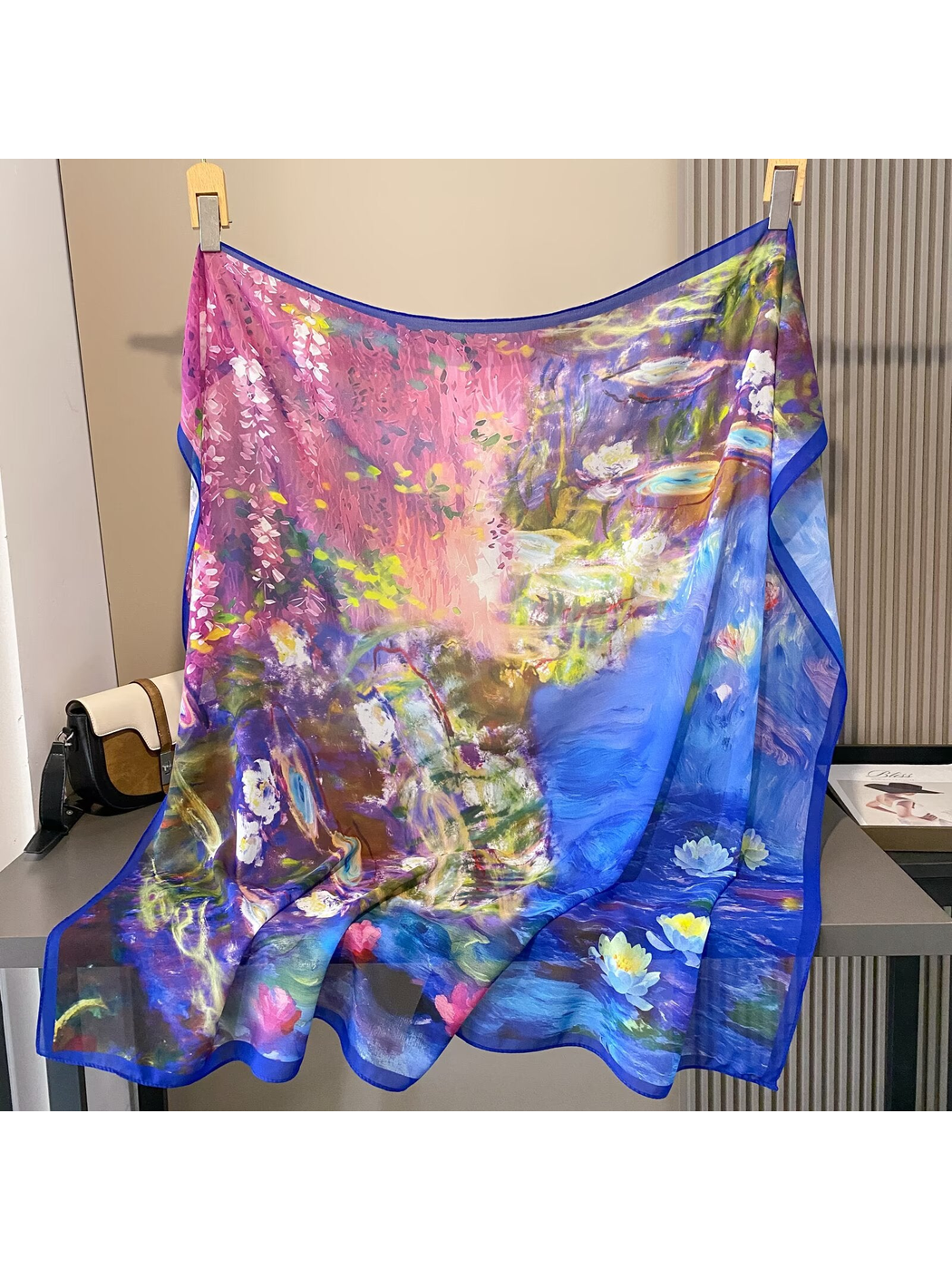Square scarf displayed open with pink blossoms, blue water and floral motifs