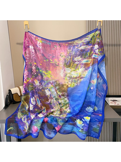 Square scarf displayed open with pink blossoms, blue water and floral motifs