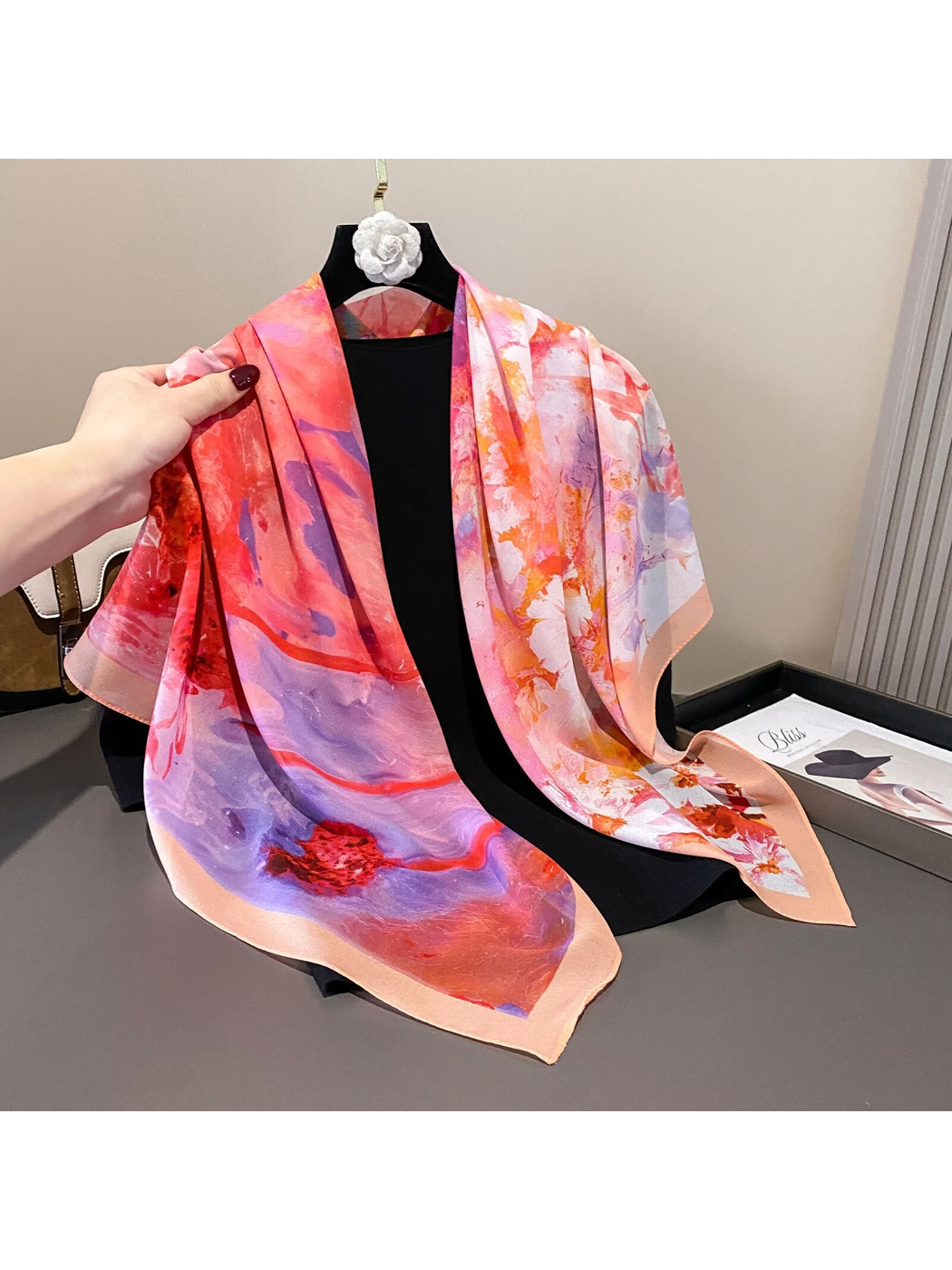 Multicolor abstract floral scarf draped loosely over a black display