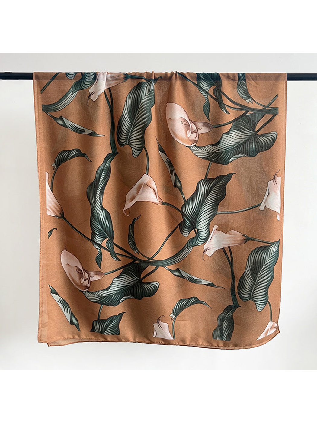 Caramel scarf with dark green leaves and pale flowers