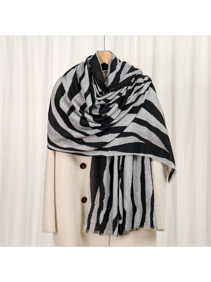 Gray and black zebra-stripe scarf draped over a cream coat
