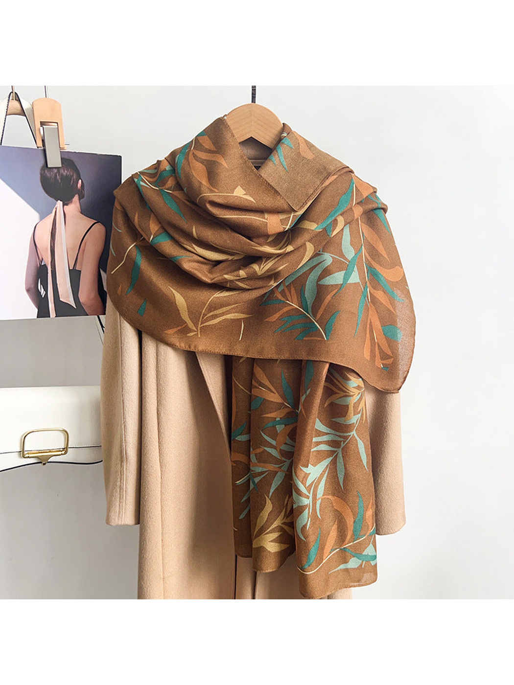 Caramel leafy branch scarf draped over a neutral coat