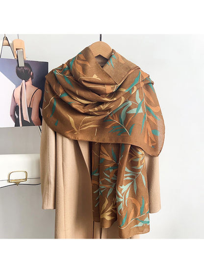 Caramel leafy branch scarf draped over a neutral coat