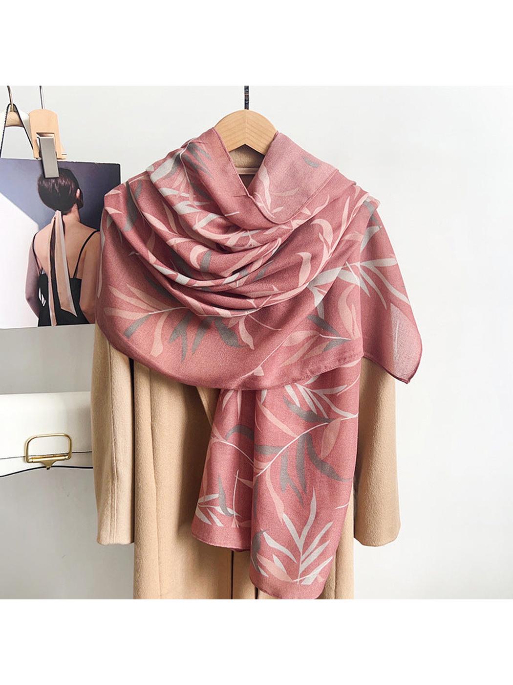 Dusty pink leafy branch scarf draped over a neutral coat