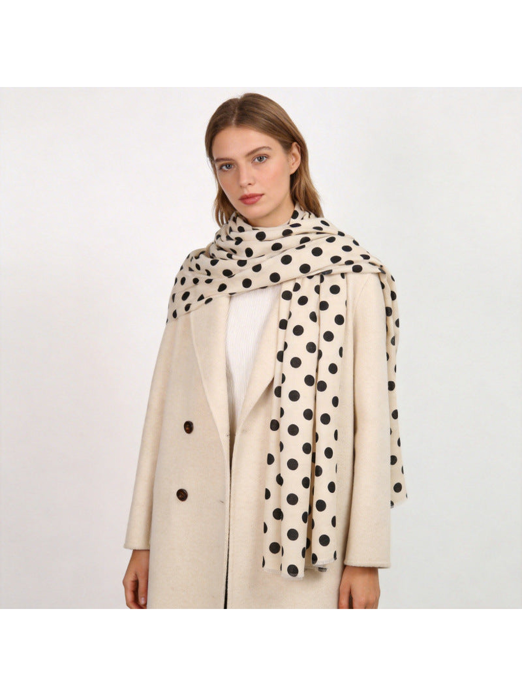 Ivory polka-dot scarf styled over a light coat