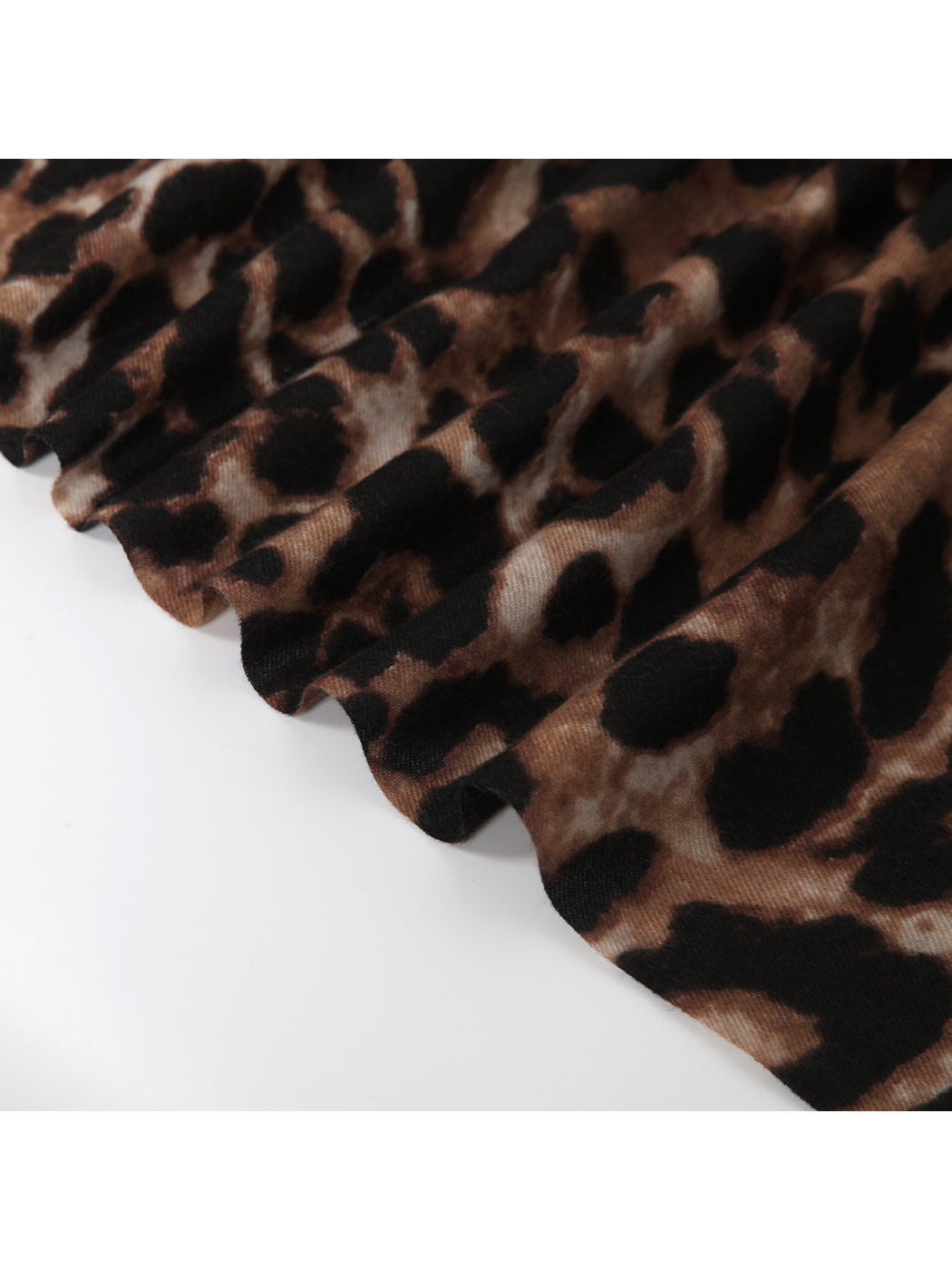 Close-up of the brown abstract leopard-print scarf edge and gathered folds