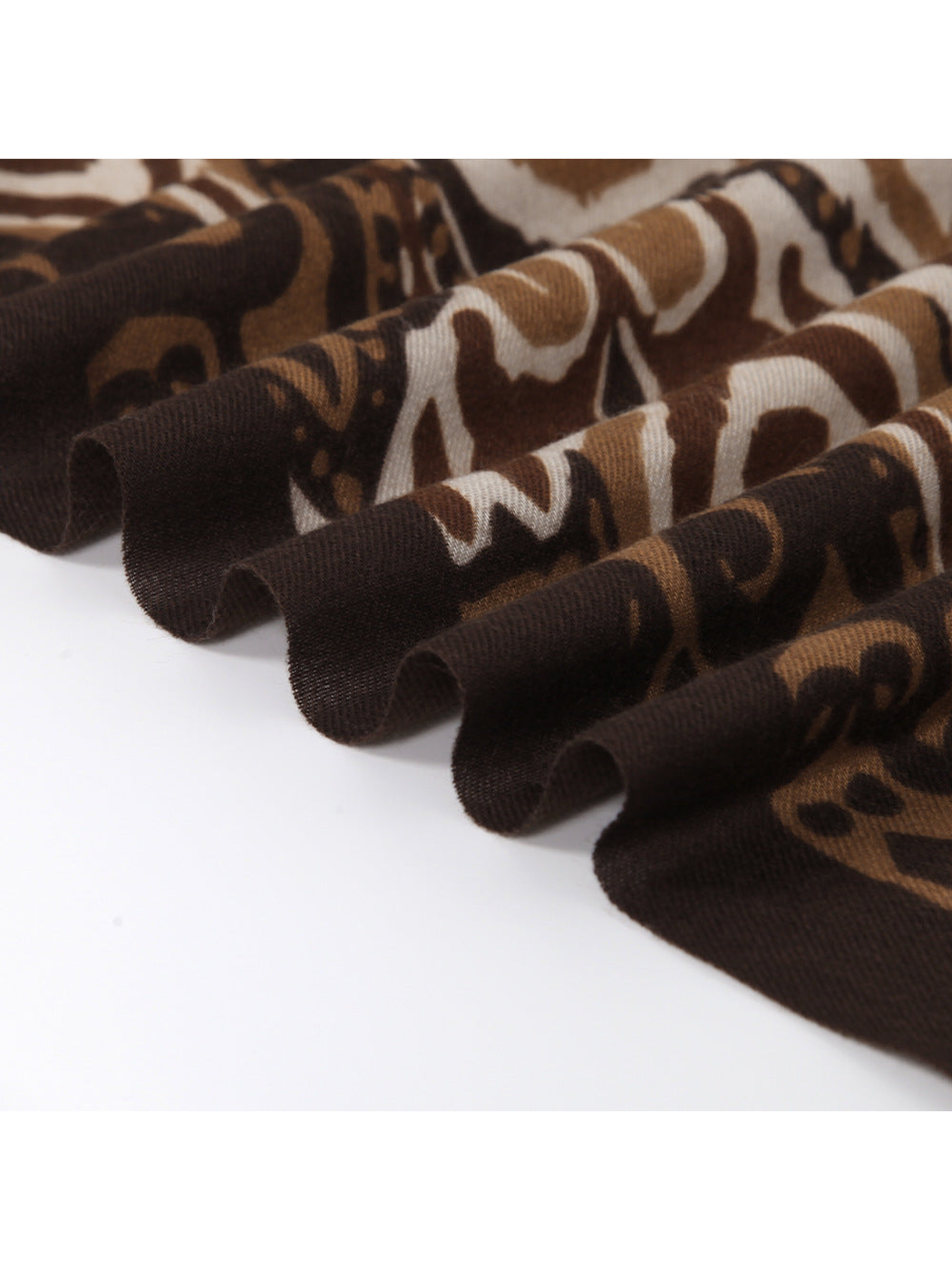 Close-up of the brown scarf's patterned surface and softly rolled edge