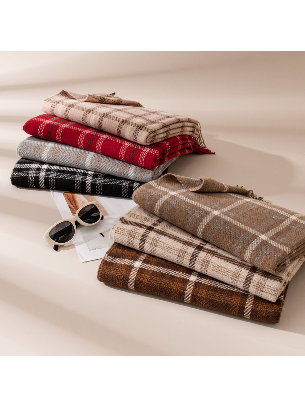 Plaid fringe scarves in assorted colors arranged in folded stacks