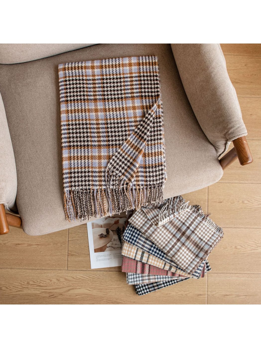 Plaid fringed scarf arranged on an armchair beside folded color options