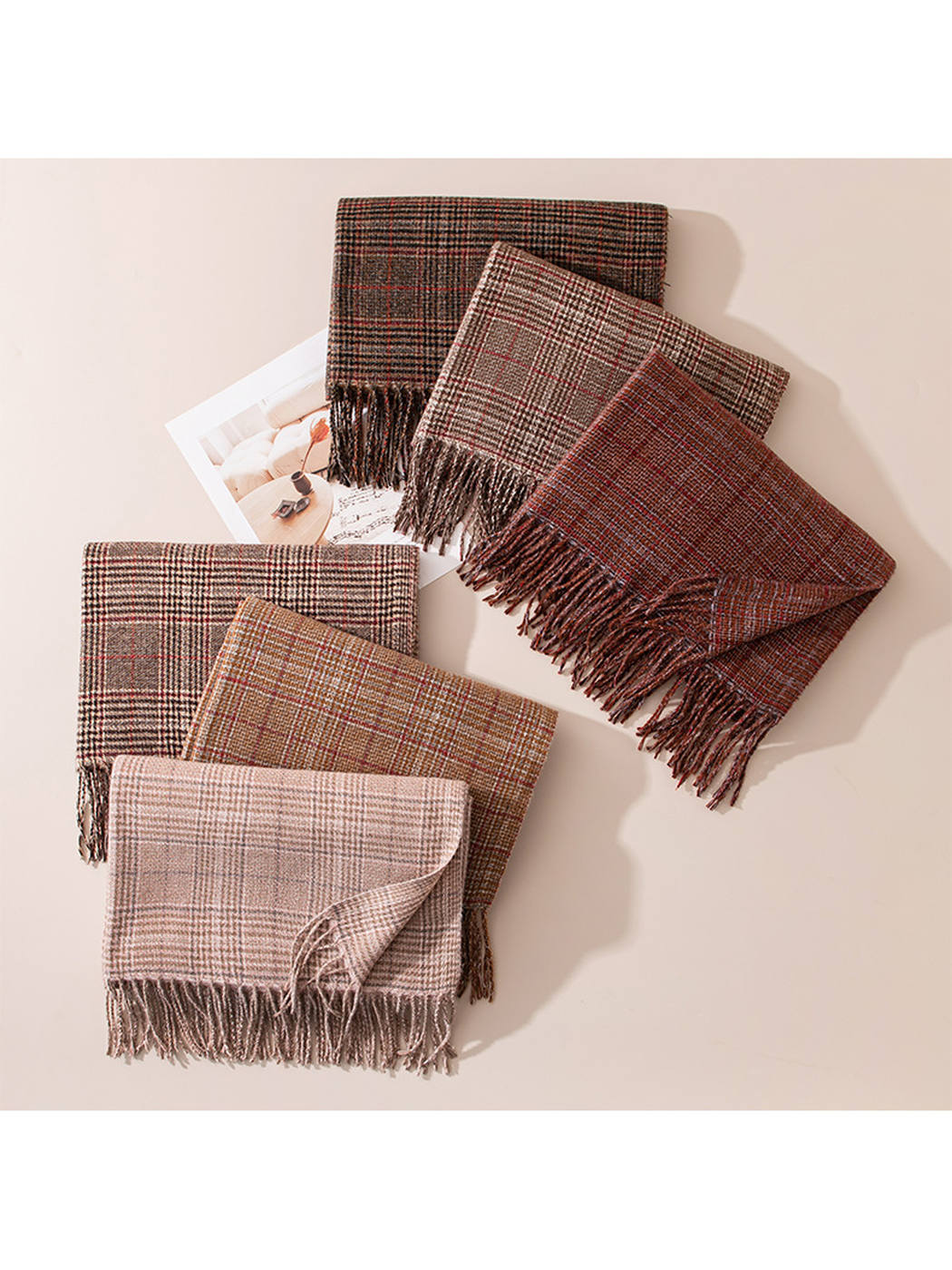 Six plaid scarves arranged flat with fringed ends visible