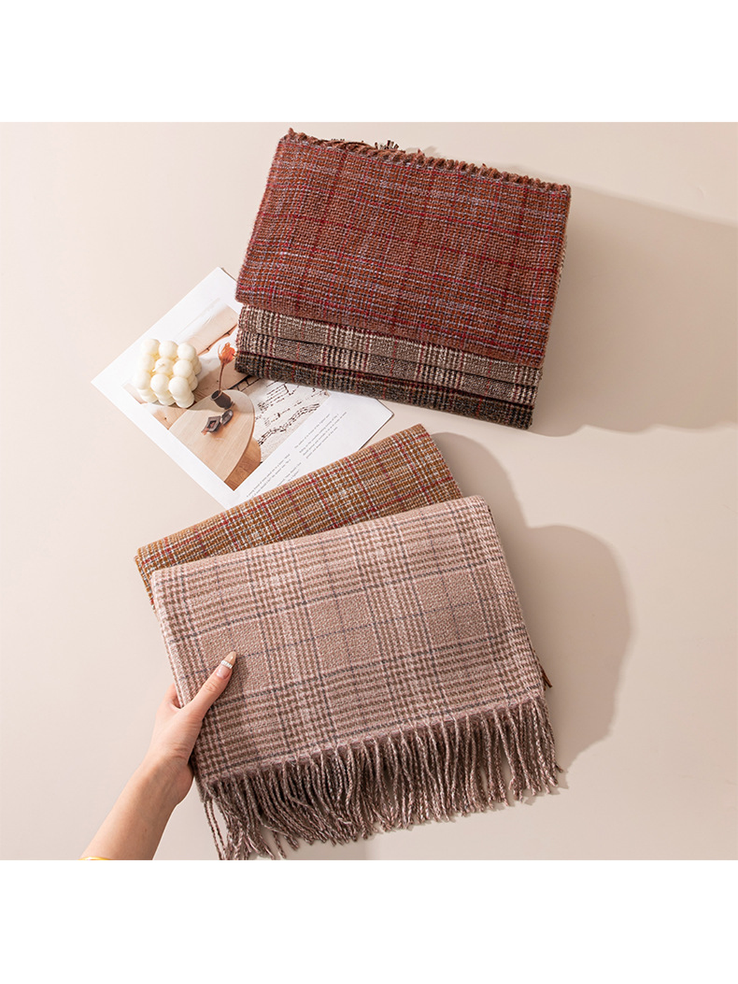 Blush plaid scarf held in front of five folded color options