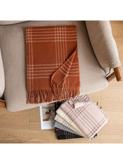 Orange plaid scarf displayed on a chair beside stacked color options