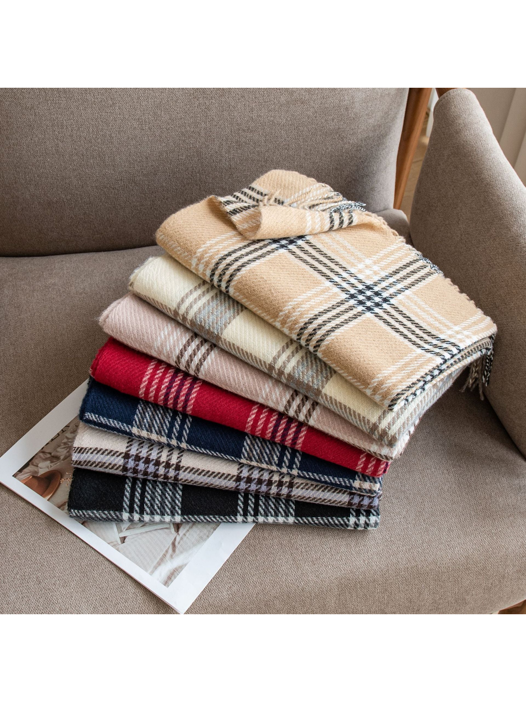 Plaid scarves in assorted colors stacked on an armchair