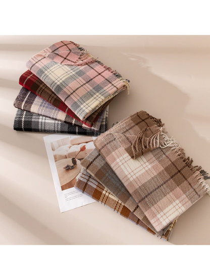 Stacks of folded plaid scarves with fringed edges