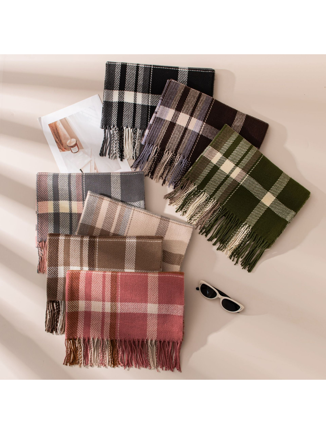 Seven plaid fringe scarf colorways arranged in an overhead display