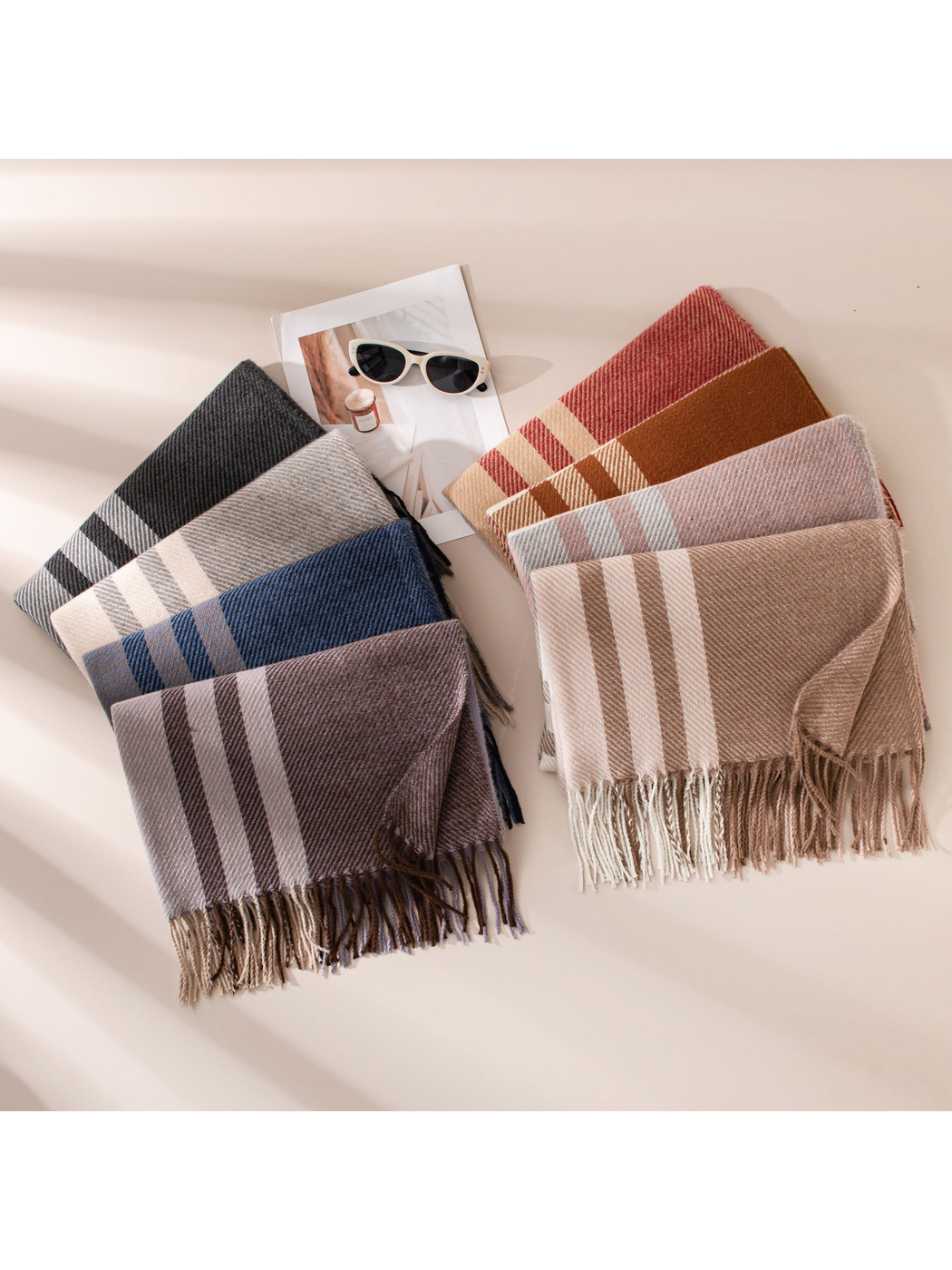 Assorted plaid scarves arranged in two color groups with fringed ends