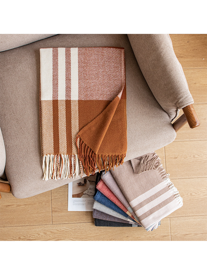 Plaid scarves arranged on an upholstered chair and wood floor