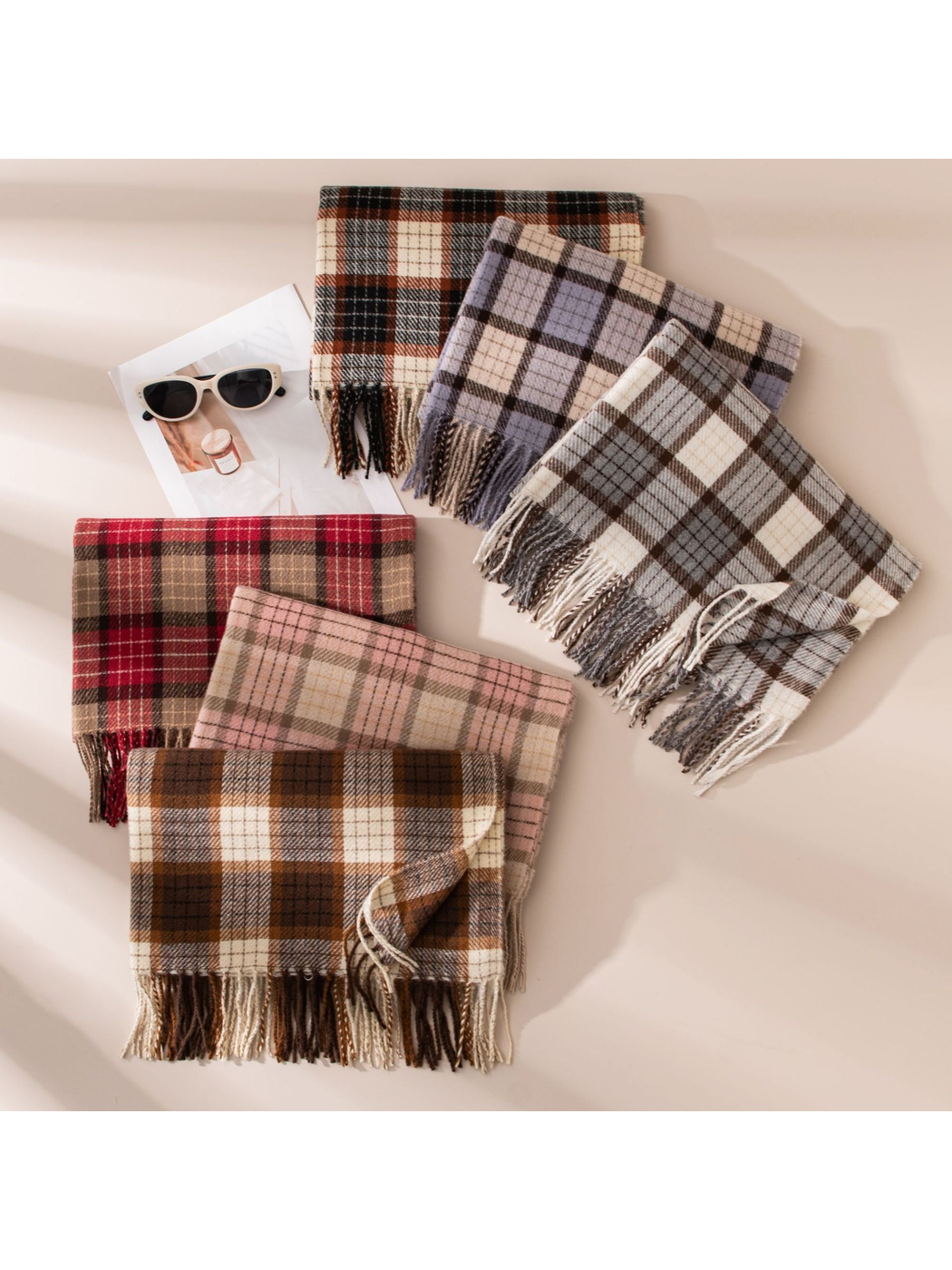Six plaid fringed scarves arranged together in assorted colors