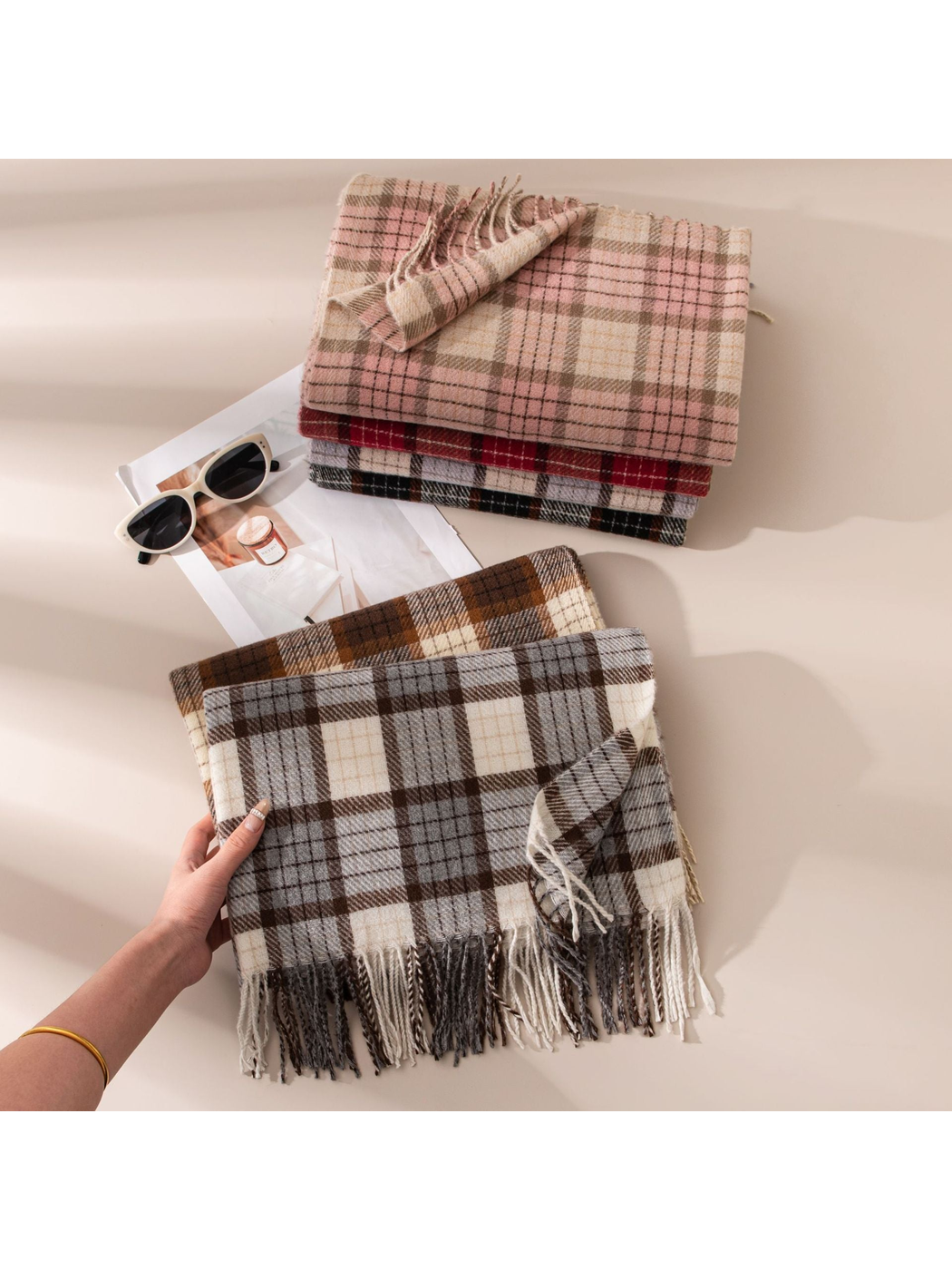 Gray plaid fringed scarf held in front of five folded color options