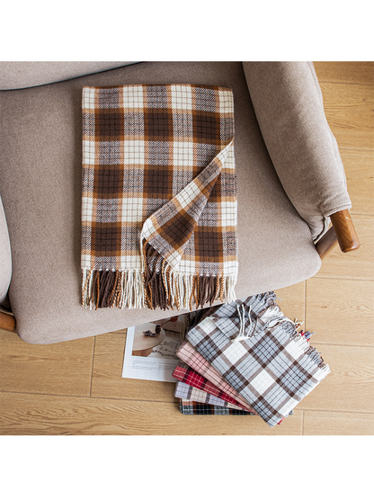 Caramel plaid scarf arranged on an armchair beside folded color options