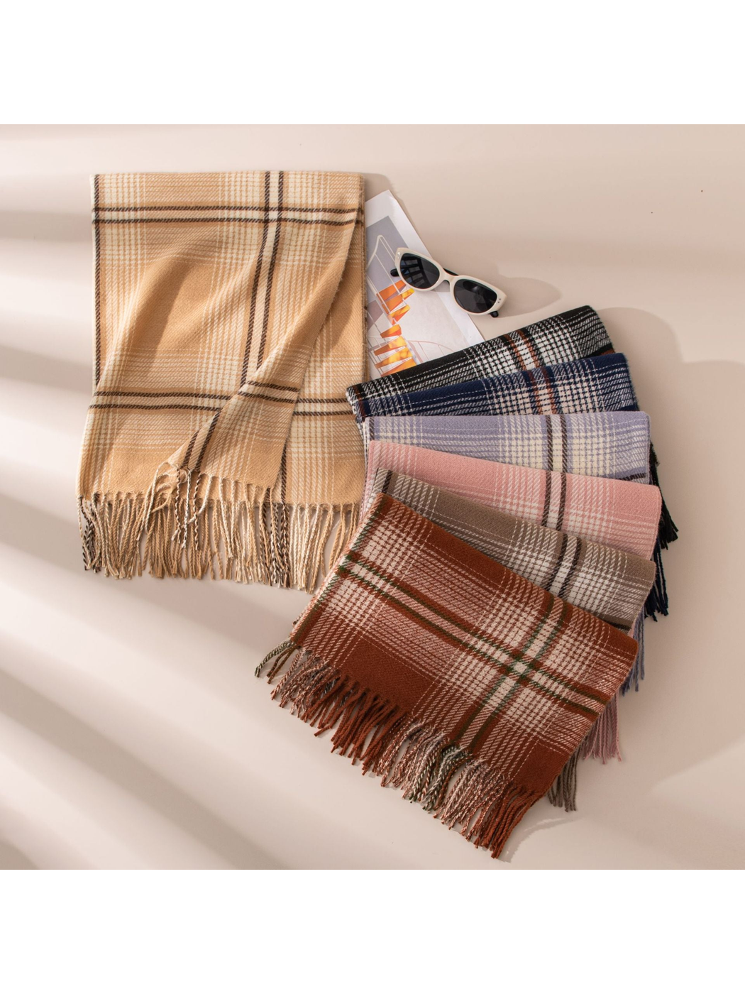 Camel plaid scarf displayed beside a fan of six additional colors