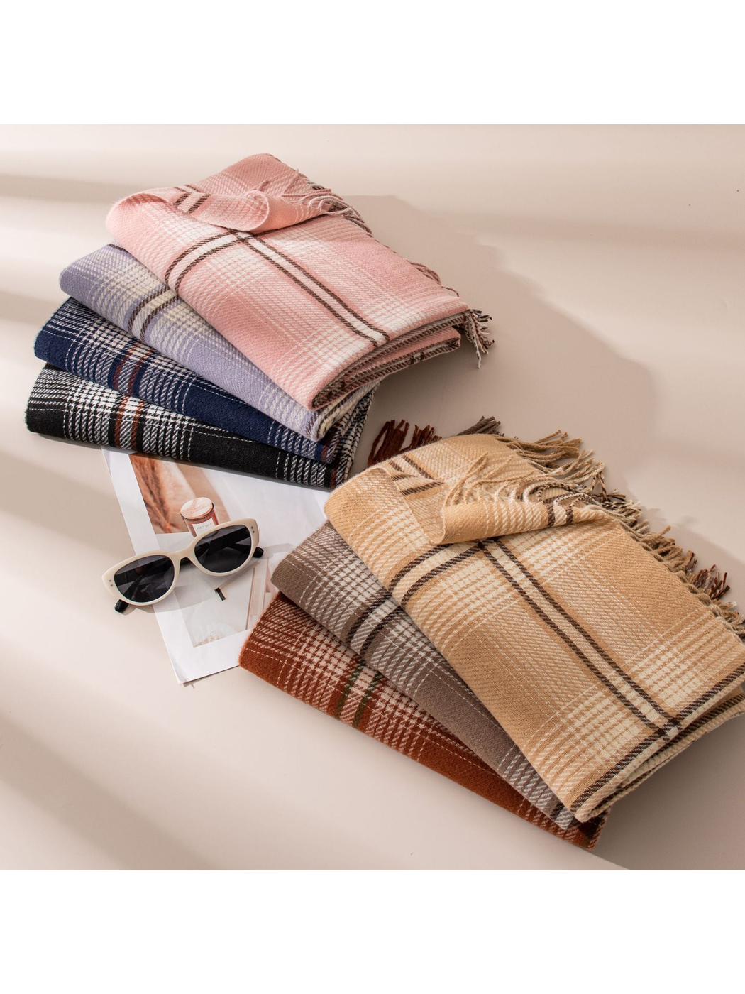 Seven plaid scarf colors arranged in two folded stacks with fringed edges visible
