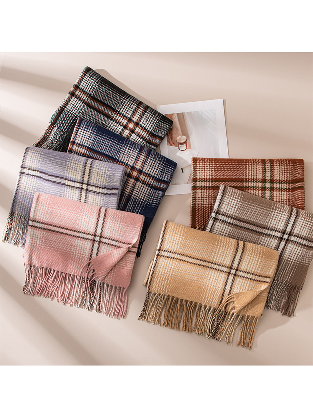 Seven plaid scarf colors arranged together with their fringed edges visible