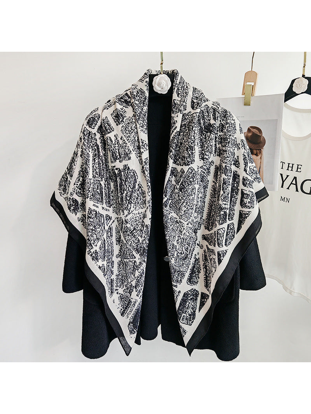 White-base city-map scarf draped loosely over a black coat