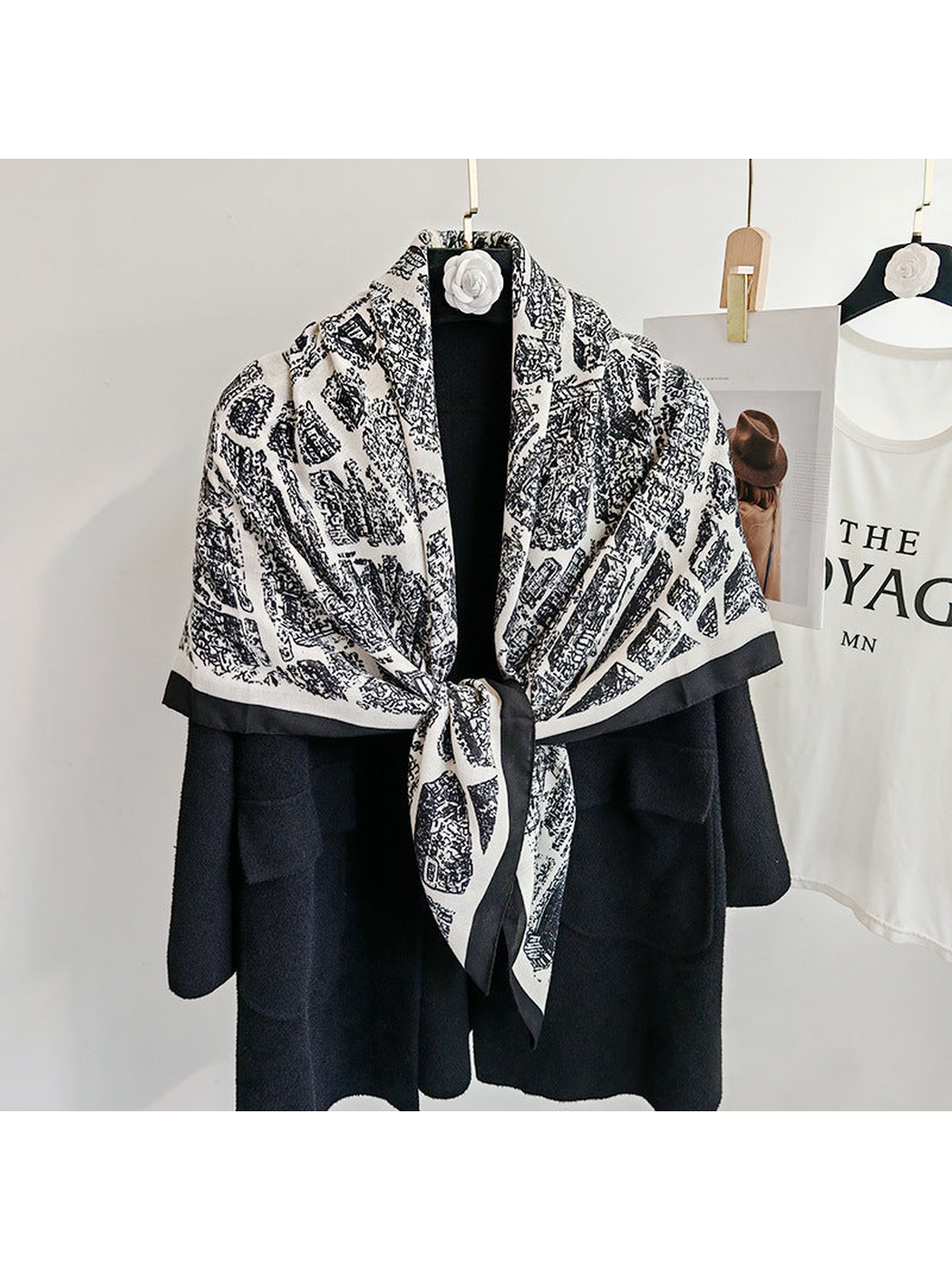 White-base city-map scarf tied at the front over a black coat
