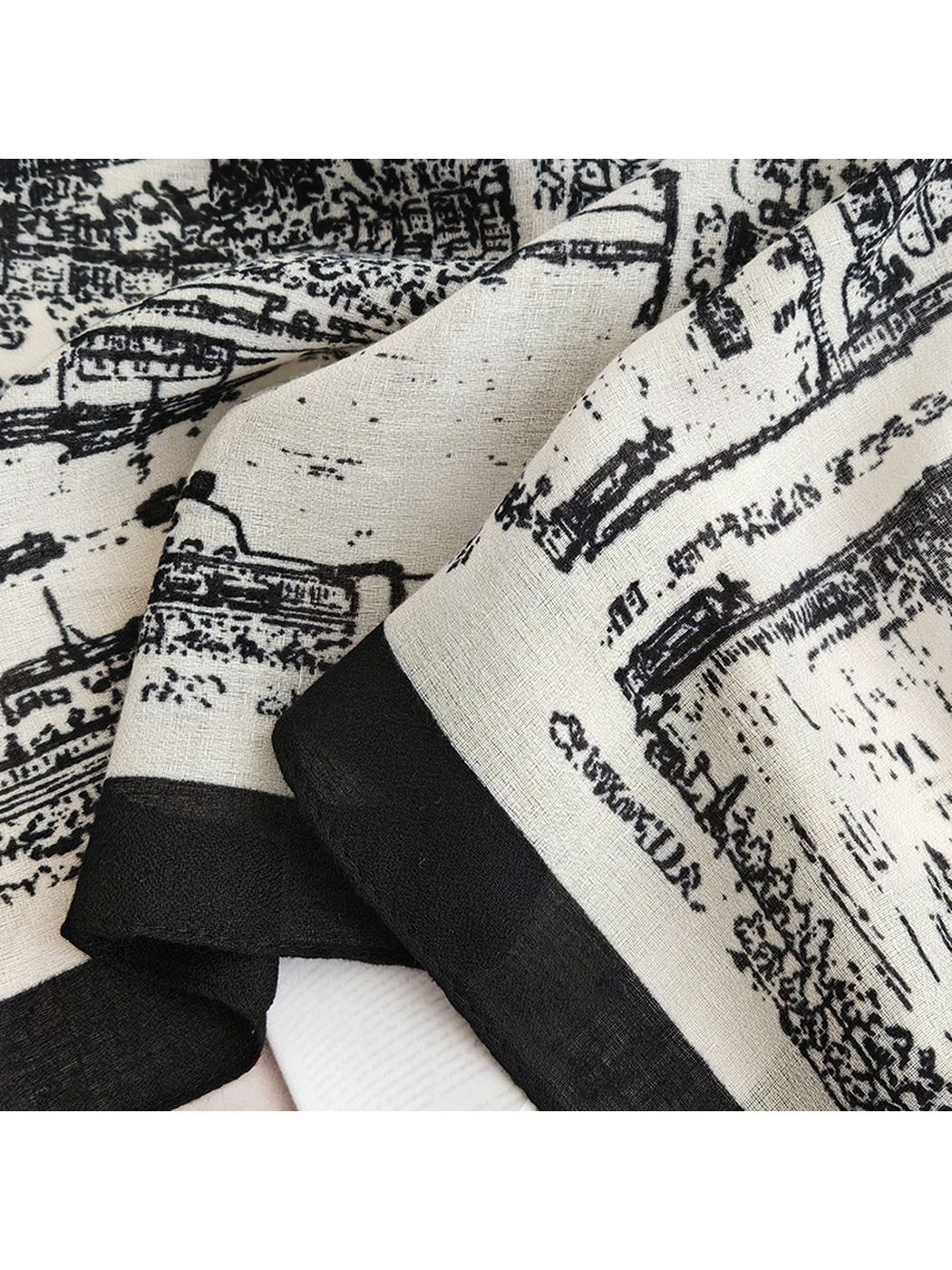 Close-up of the white-base scarf's fine woven-look texture and black border