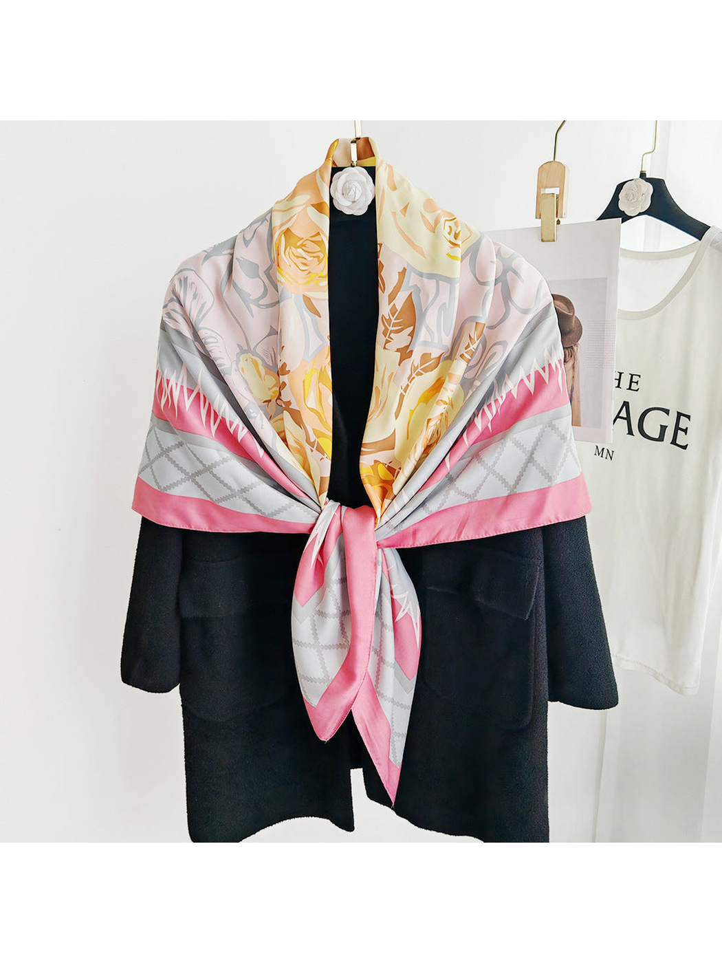 Pink floral square scarf tied over a black coat