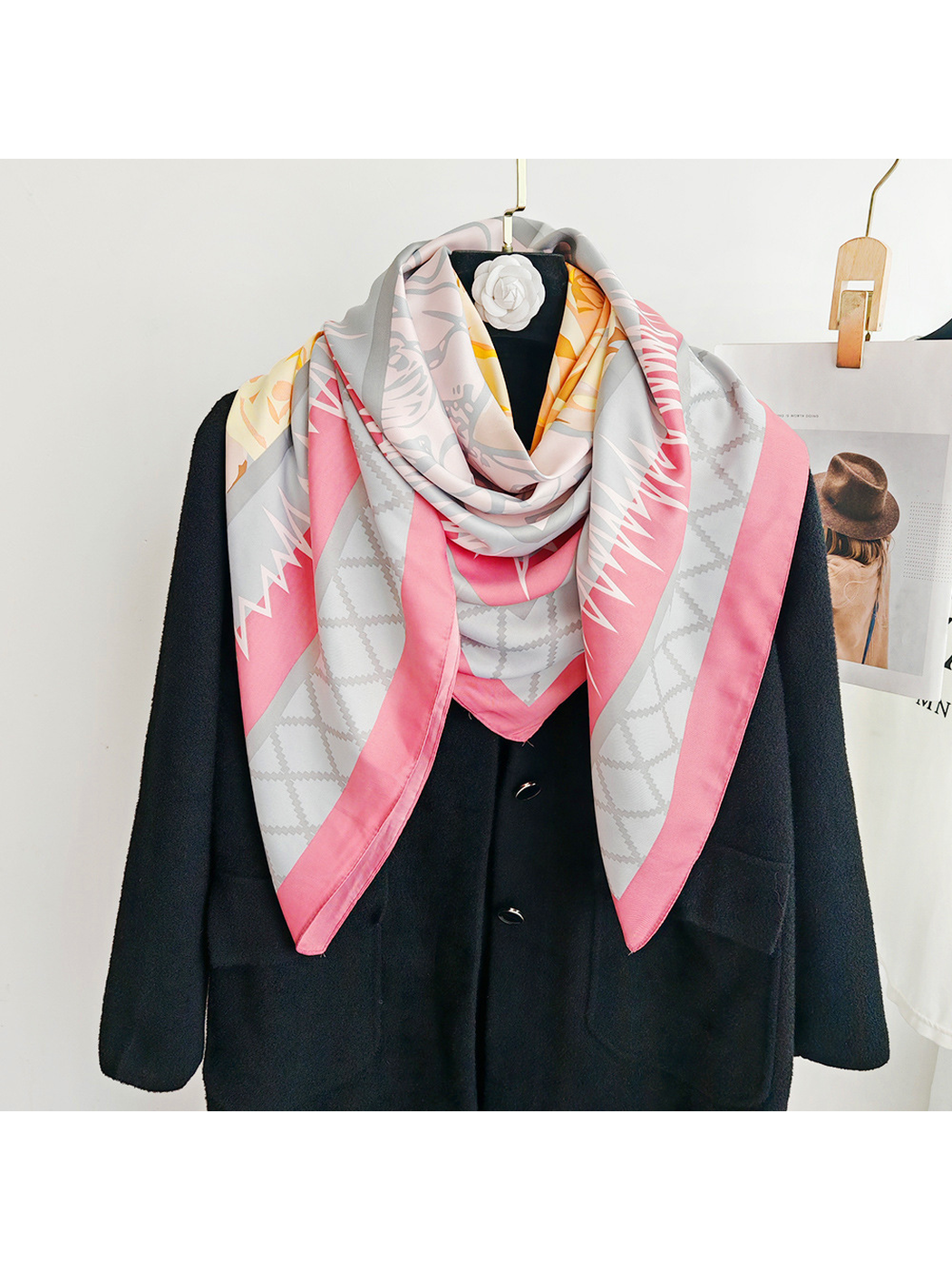 Pink floral square scarf wrapped closely around the neck with pointed ends
