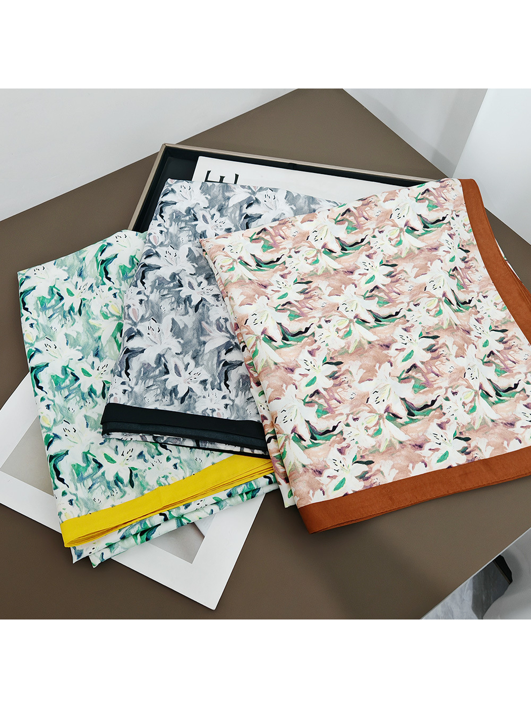 Three abstract floral square scarf colors displayed folded together