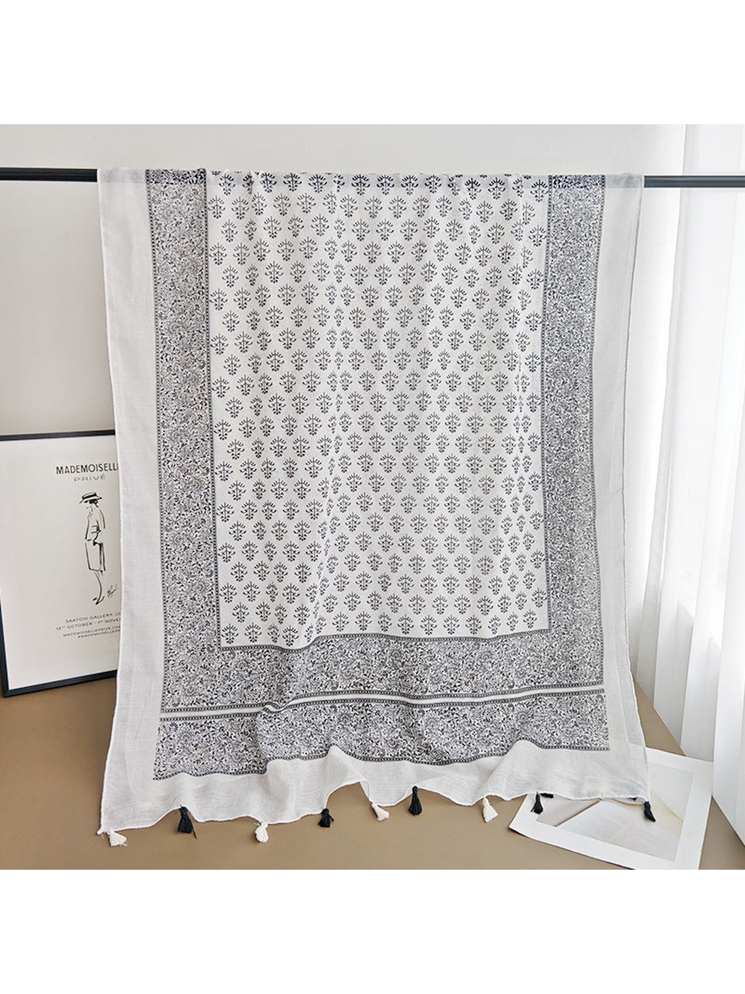 Black and white rectangular scarf displayed open to show the full botanical pattern and border